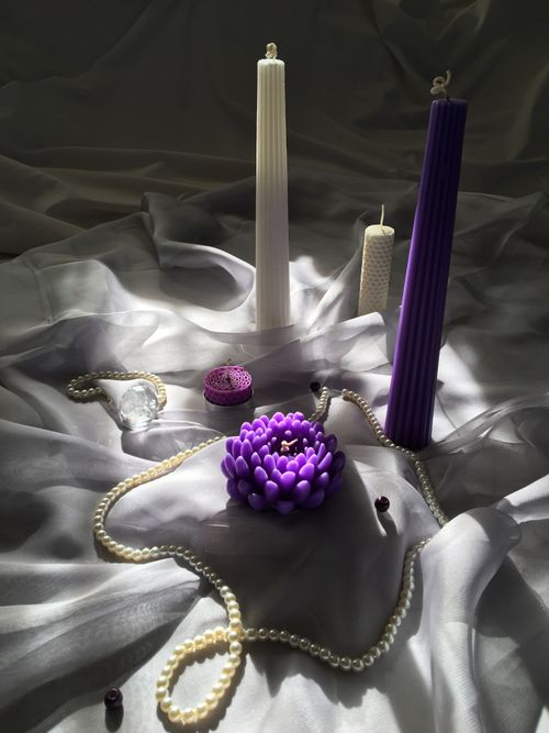 Free Sophisticated still life with candles, pearls, and silk creating a serene atmosphere. Stock Photo