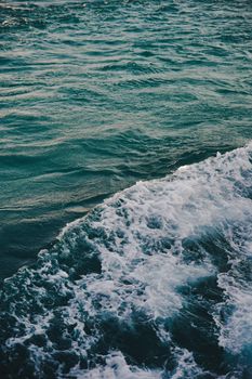 海浪沿着海面撞击的高角度视图，展现出充满活力的青色色调