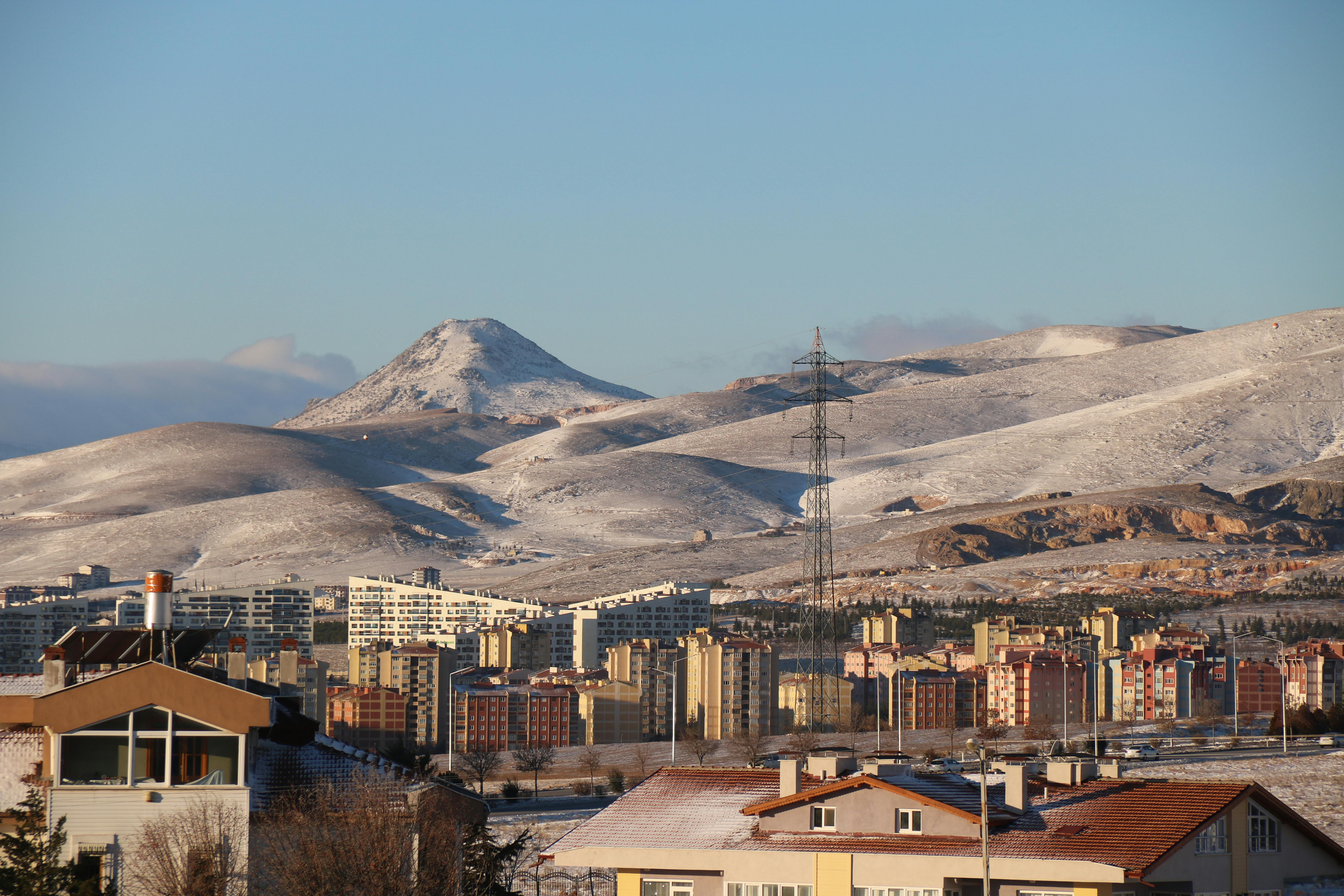 科尼亚城市景观中，雪山的冬季视图与住宅建筑相得益彰