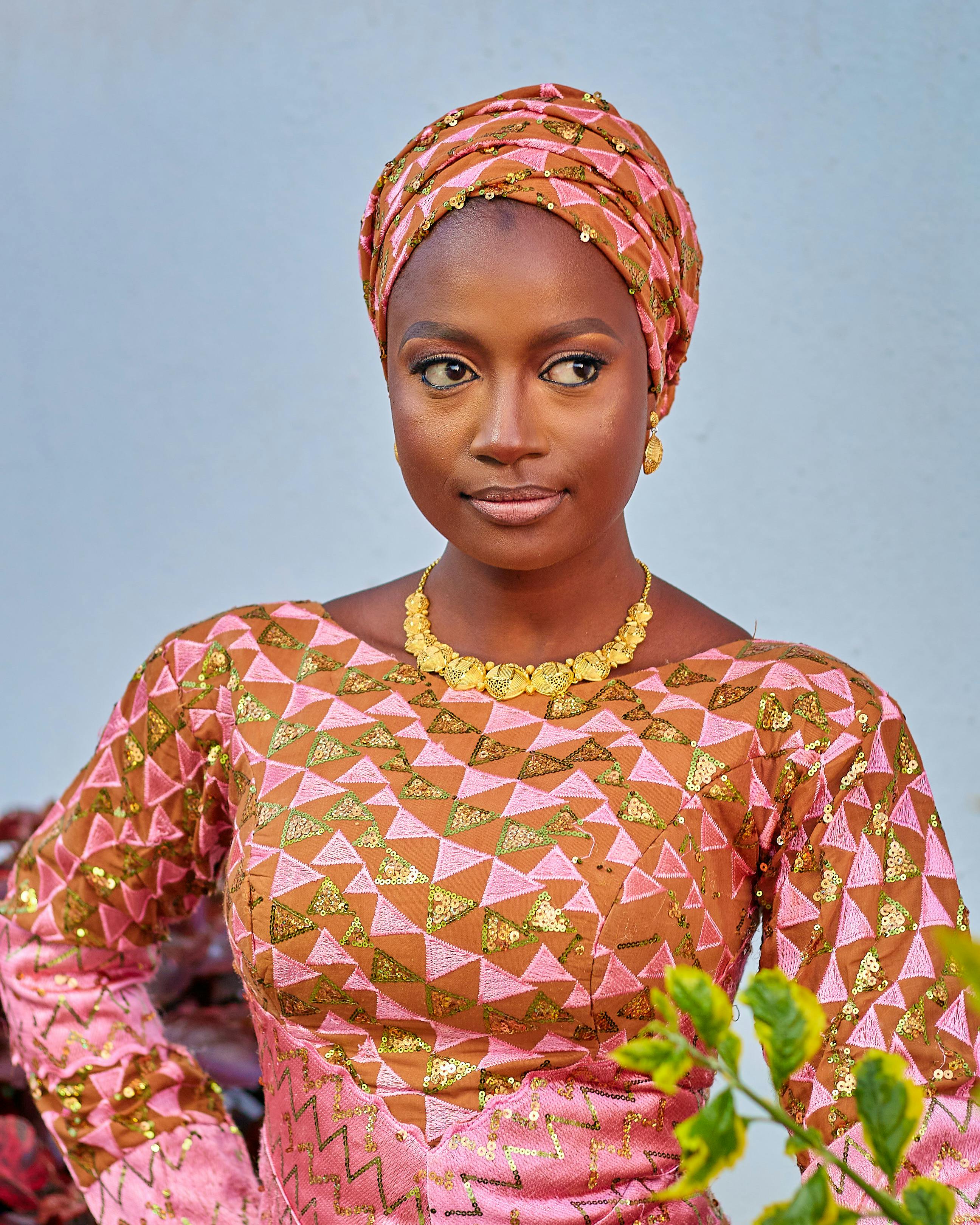 Portrait of a confident woman in vibrant African clothing with head wrap.