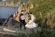 新娘和新郎在岩石峭壁上欣赏风景优美的海岸婚礼舞蹈