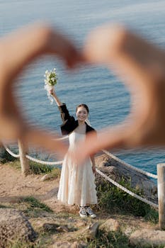 新娘微笑着，用双手勾勒出海景的轮廓