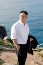 Stylish Man in White Shirt by Ocean Coast