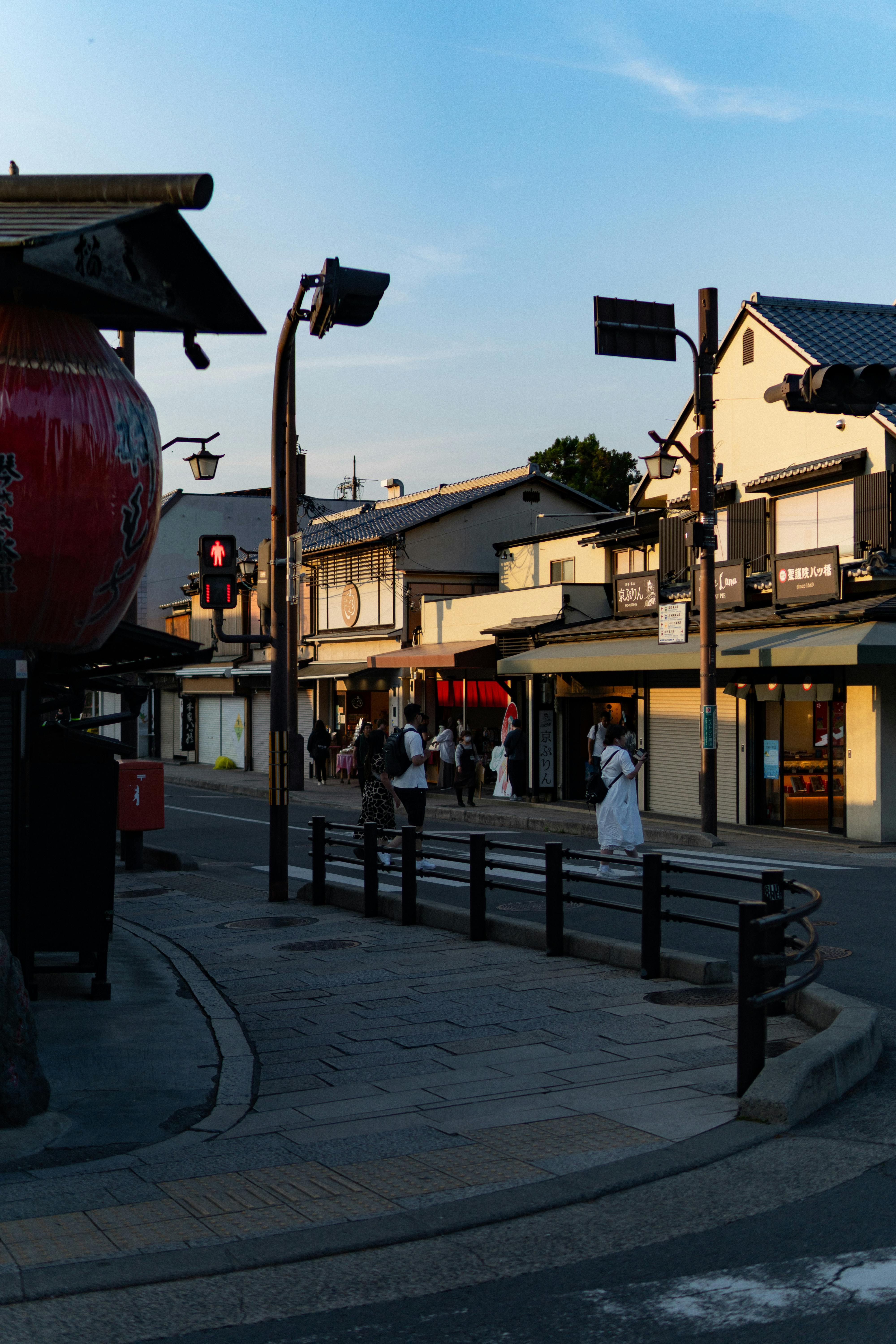 迷人的京都街景在黄昏时分展现其独特的魅力，传统建筑和人们漫步其间，营造出一种宁静而浪漫的氛围