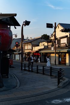 迷人的京都街景在黄昏时分展现其独特的魅力，传统建筑和人们漫步其间，营造出一种宁静而浪漫的氛围