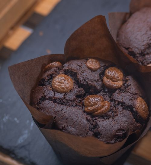 Free Delicious chocolate muffins with chocolate chips on a slate surface, wrapped in paper liners. Stock Photo