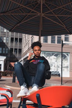 年轻人在城市街道的户外随意坐着，用智能手机聊天