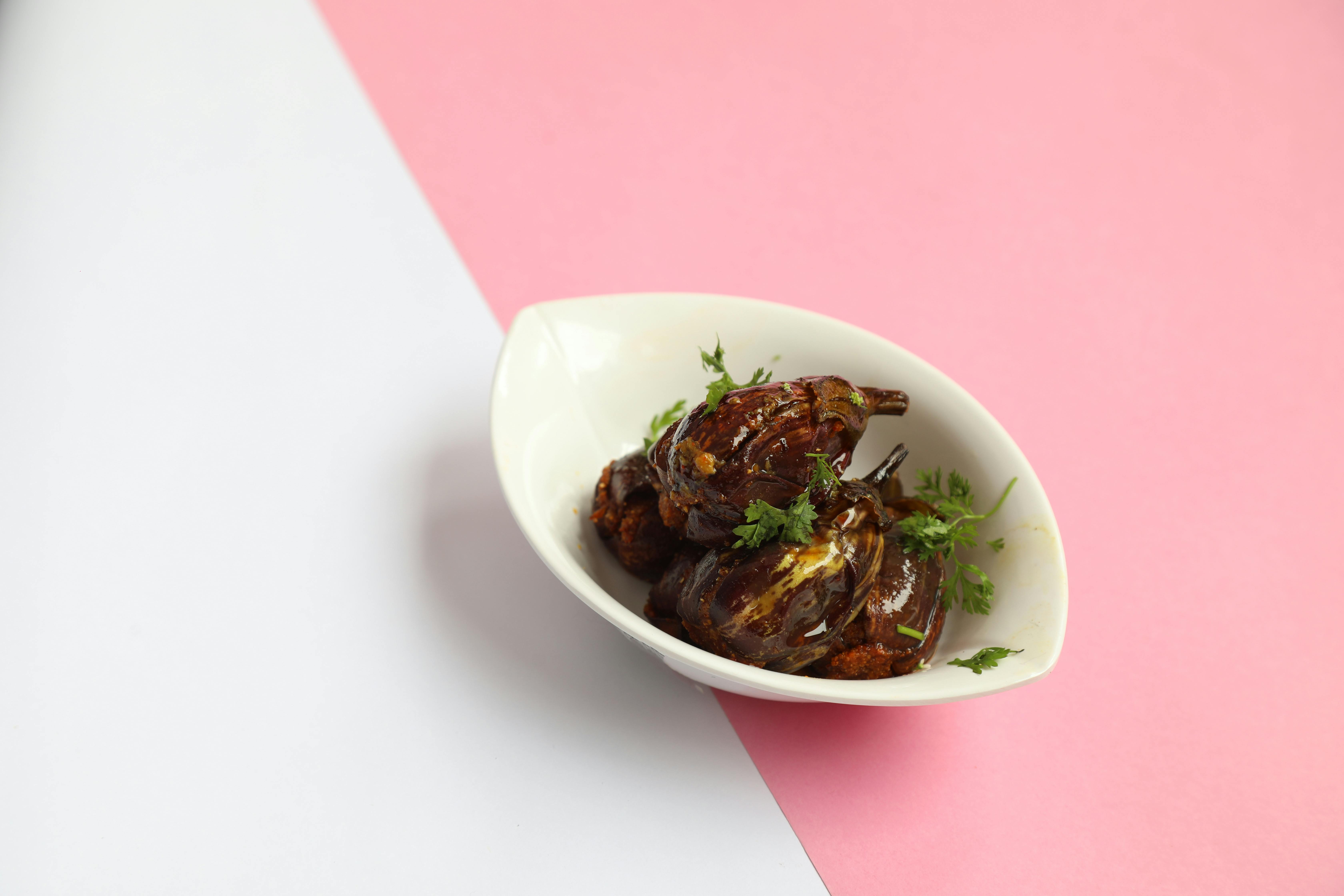 Gratis Delizioso curry di melanzane ripiene guarnito con coriandolo fresco, servito in un ambiente moderno e minimalista. Foto a disposizione