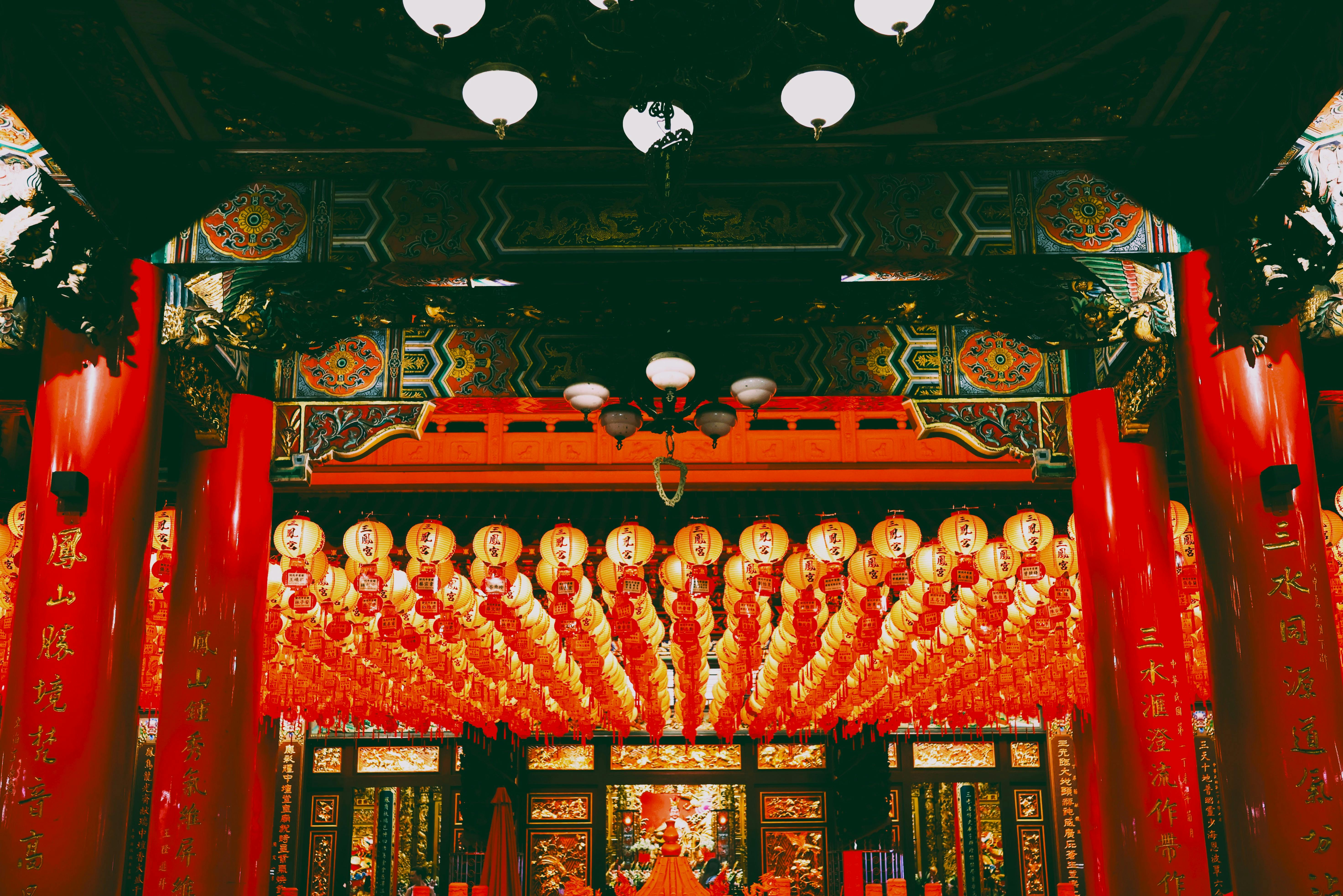 Vibrant interior of a Taiwanese temple adorned with red lanterns and intricate decorations.