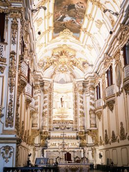 Luxurious Baroque church interior with intricate gold detailing and religious art.