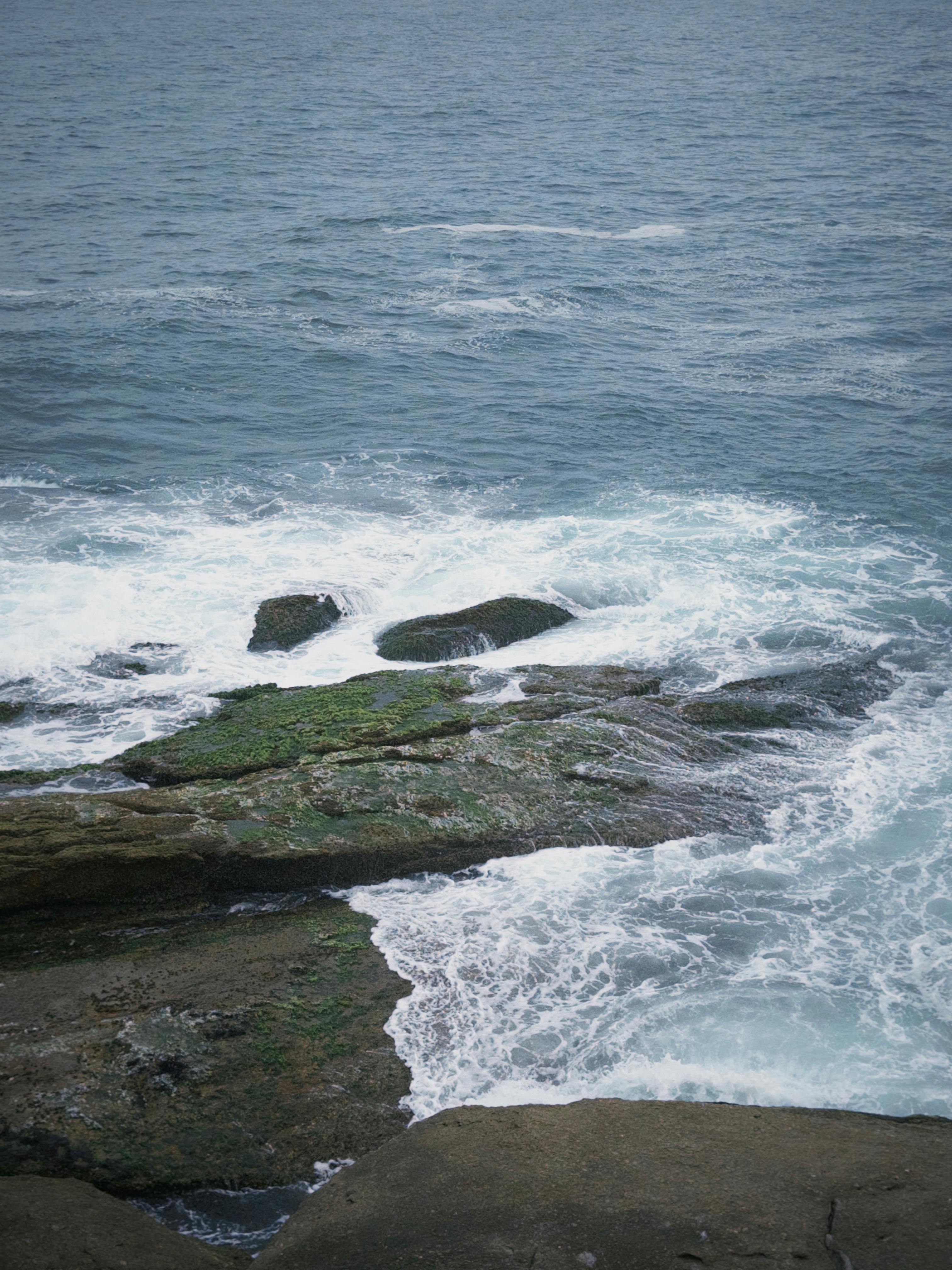 宁静的海浪撞击岩石海岸，展示了自然的纹理