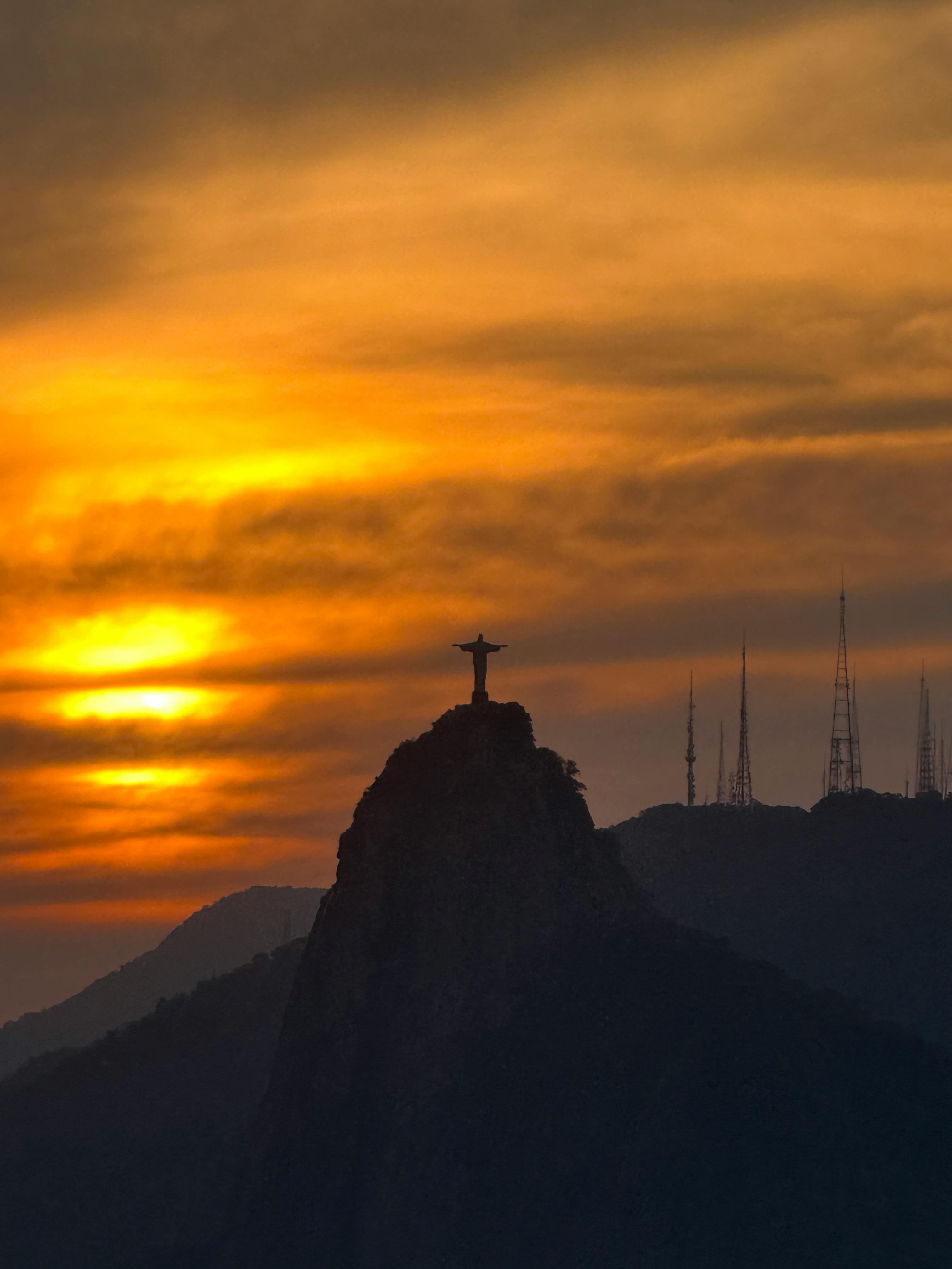 在里约热内卢的日落时分，基督救世主的迷人景色吸引了众多游客