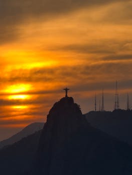 在里约热内卢的日落时分，基督救世主的迷人景色吸引了众多游客