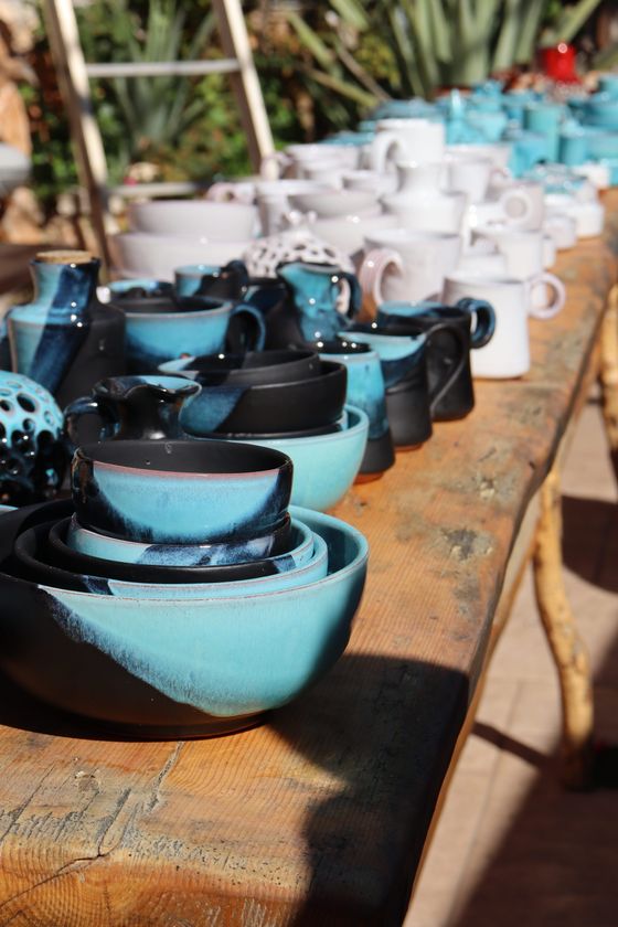 Glazed stoneware bowls and mugs on a market table — photo by Alina Zerkalii on Pexels