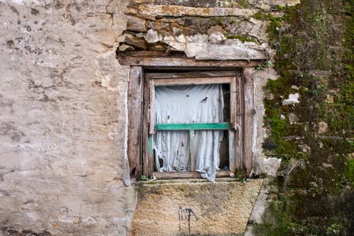 Free A rustic, decayed window in an abandoned building, surrounded by moss and cracked stone walls. Stock Photo