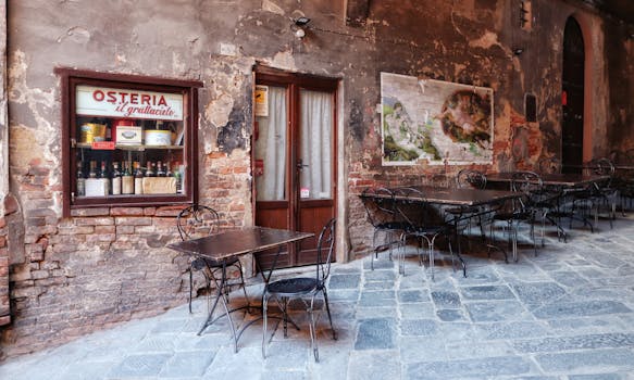 Vintage outdoor cafe setting with empty tables in historic Italian street.