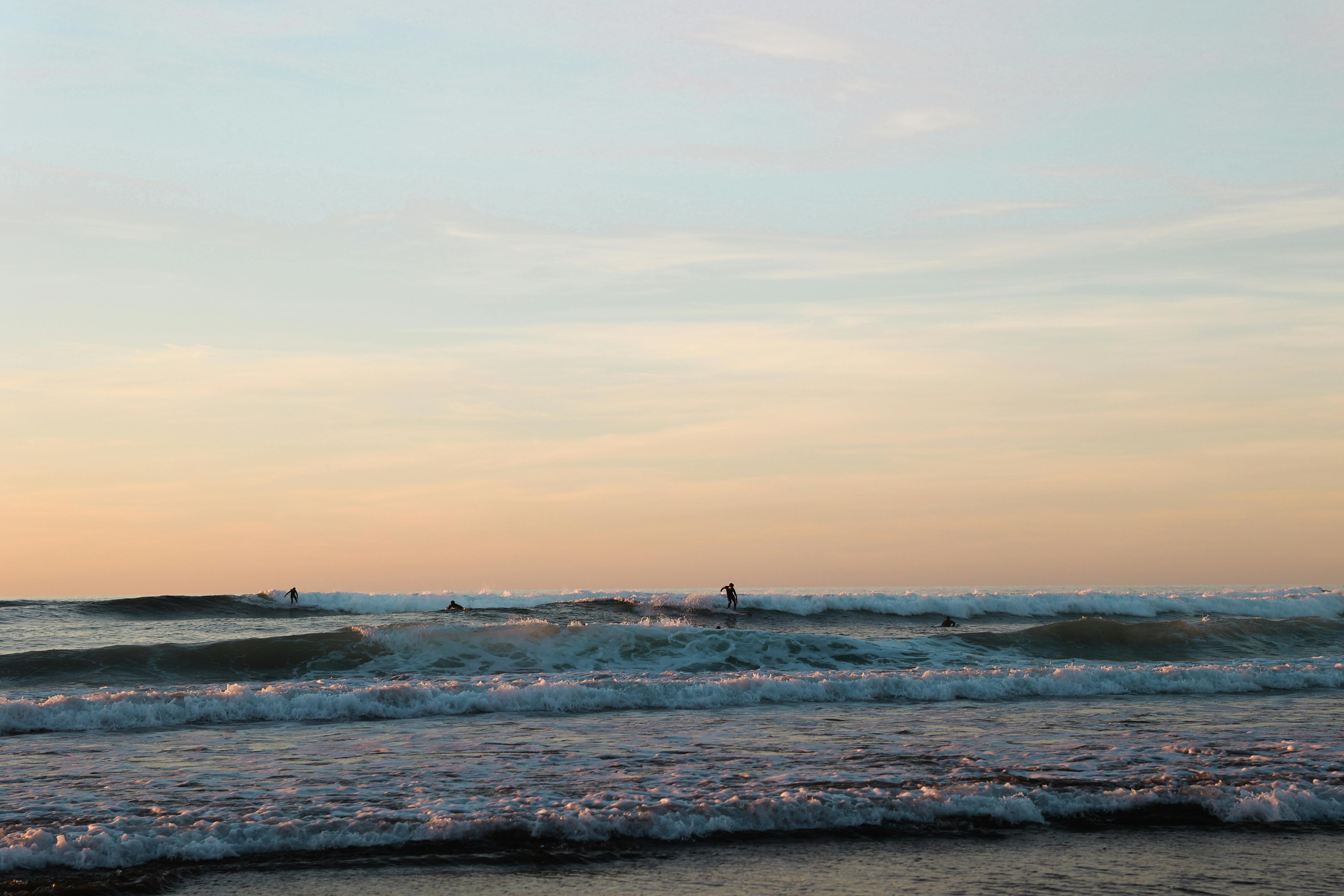 在西班牙佩斯瓦斯科的壮丽日落中，冲浪者享受海浪，捕捉充满活力的氛围