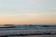 在西班牙佩斯瓦斯科的壮丽日落中，冲浪者享受海浪，捕捉充满活力的氛围