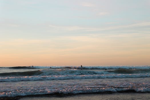 在西班牙佩斯瓦斯科的壮丽日落中，冲浪者享受海浪，捕捉充满活力的氛围