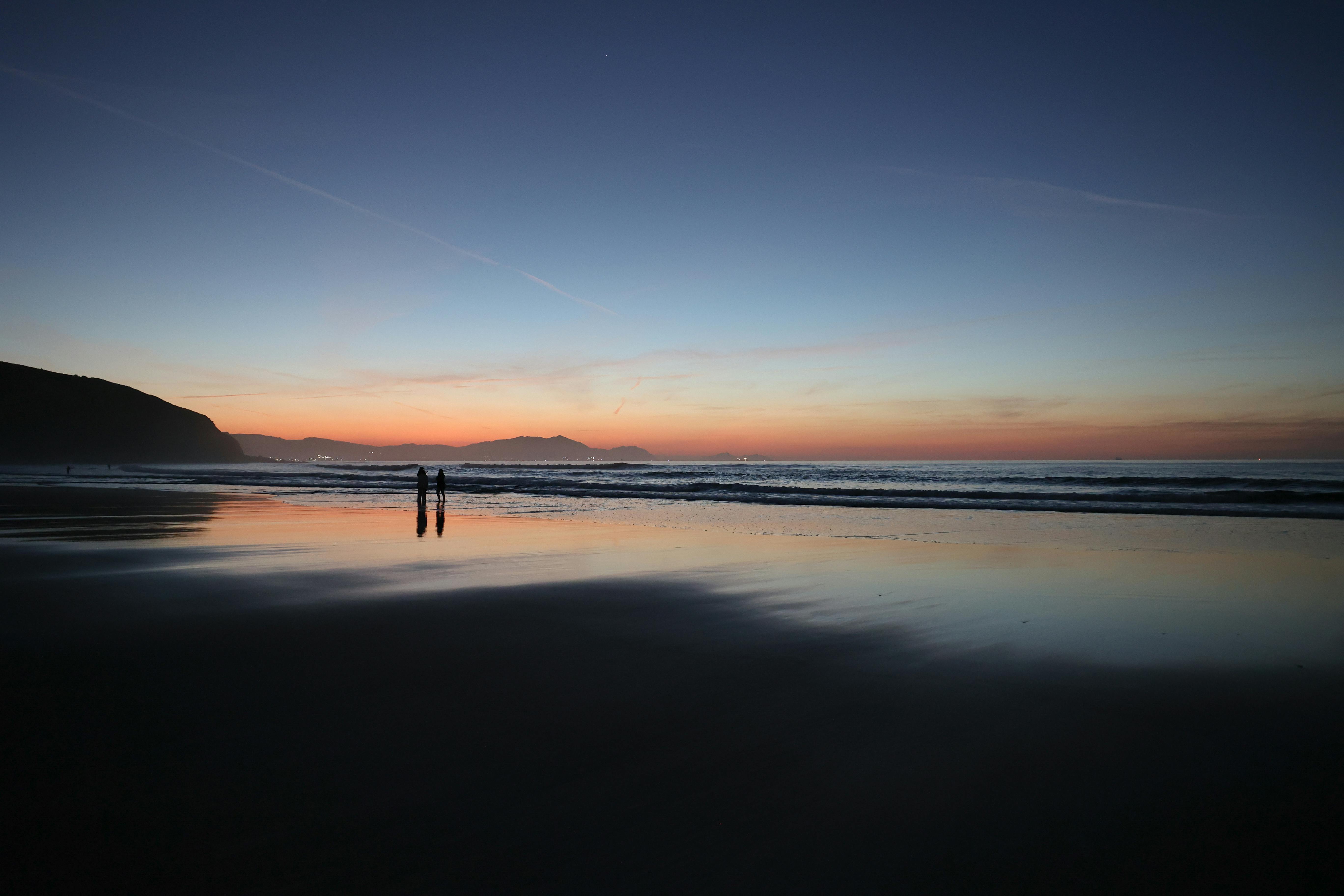 在西班牙巴斯克的宁静海滩上，日落时分的景色令人惊叹