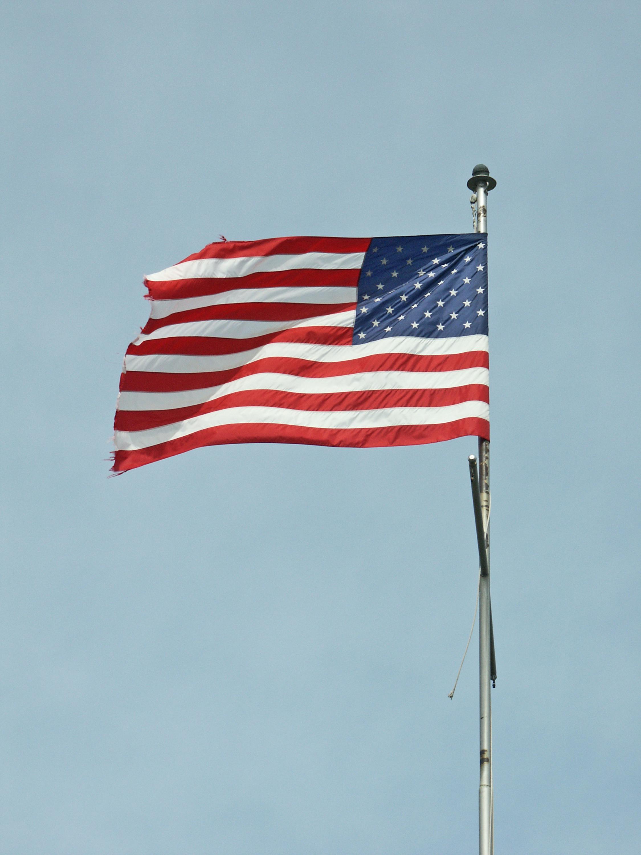 一面破旧的美国国旗在微风中僵硬地飘扬