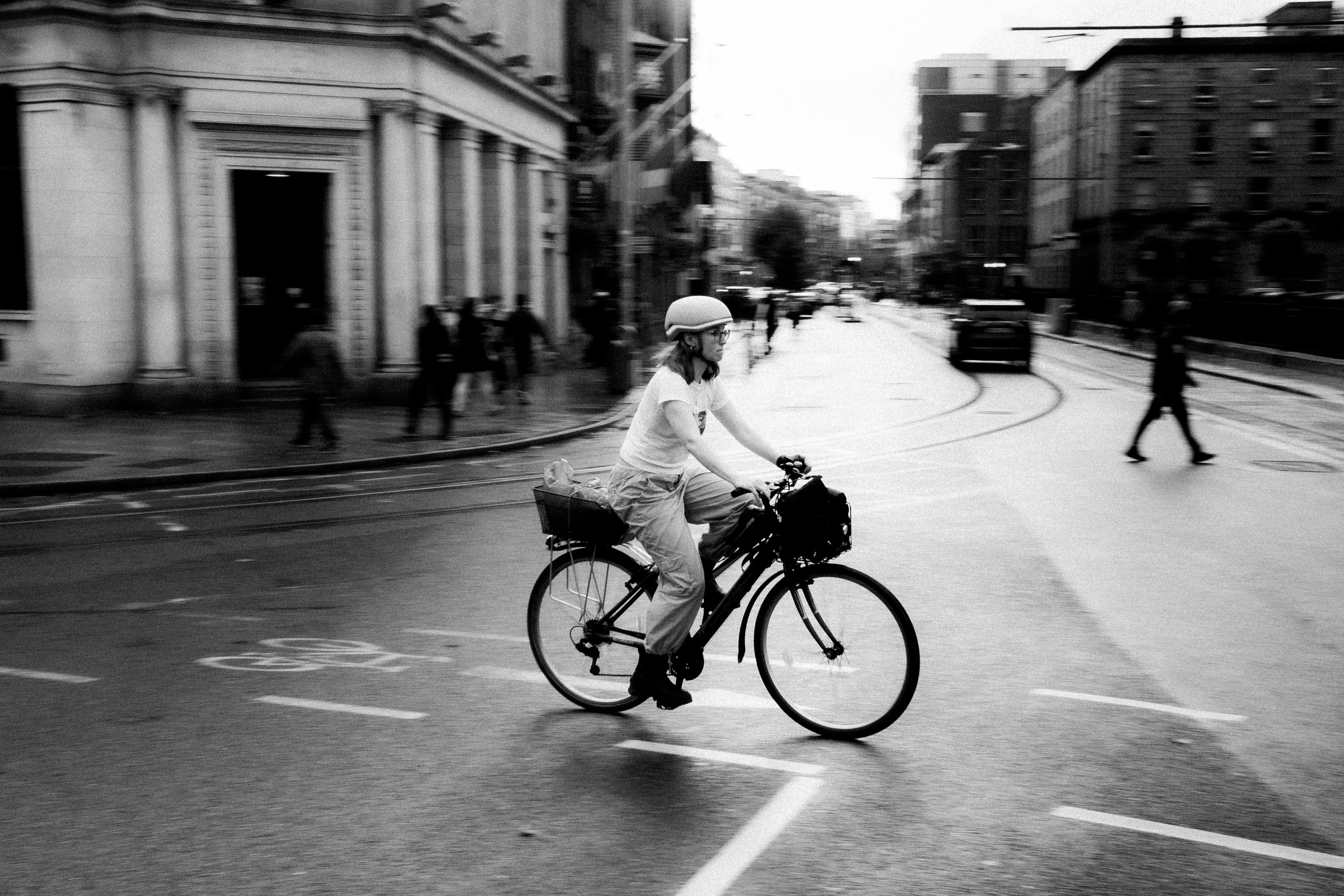 Black and white photo of a cyclist navigating urban streets in Dublin, Ireland. - Dublín