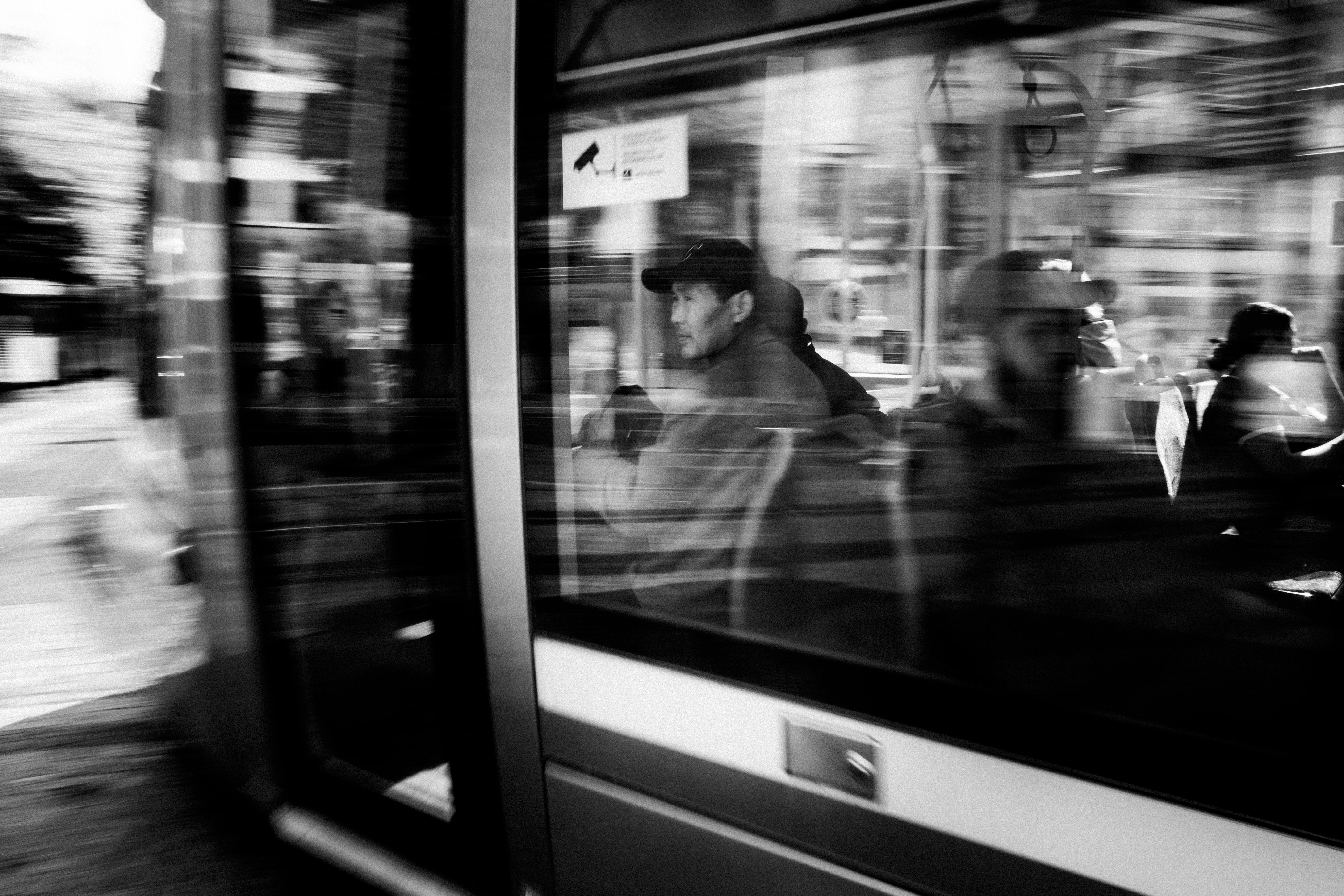Dramatic black and white photo capturing passengers on a moving tram in Dublin, Ireland. - Dublín