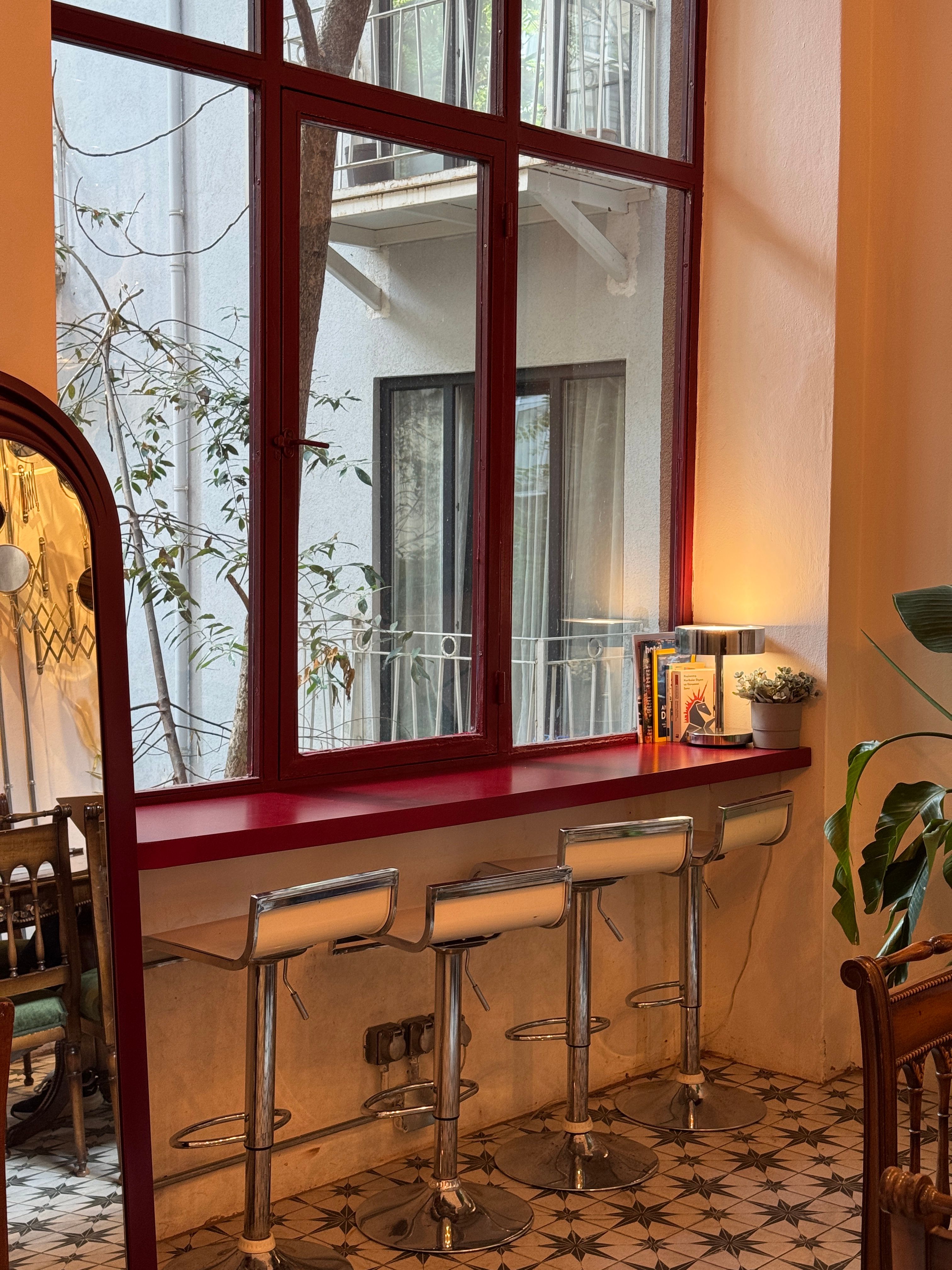 Cozy Café Interior with Red Accents and Window View · Free Stock Photo