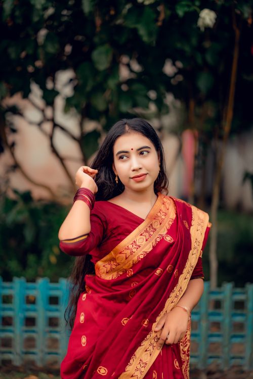 Free Beautiful portrait of a woman in traditional Bengali saree, capturing elegance and cultural richness. Stock Photo