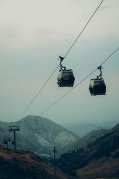 缆车在哈萨克斯坦阿拉木图的山脉中上升，为旅行者带来宁静的体验