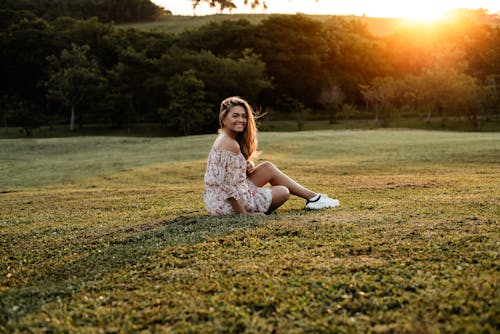 Woman Sitting on Green Grass Field