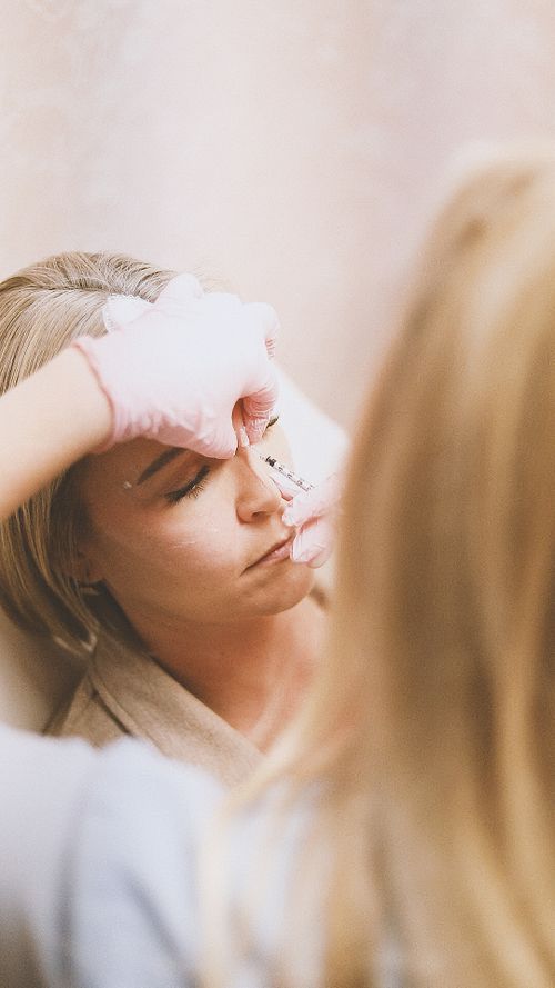 Free Close-up of a woman receiving a cosmetic injection at a modern beauty clinic. Stock Photo
