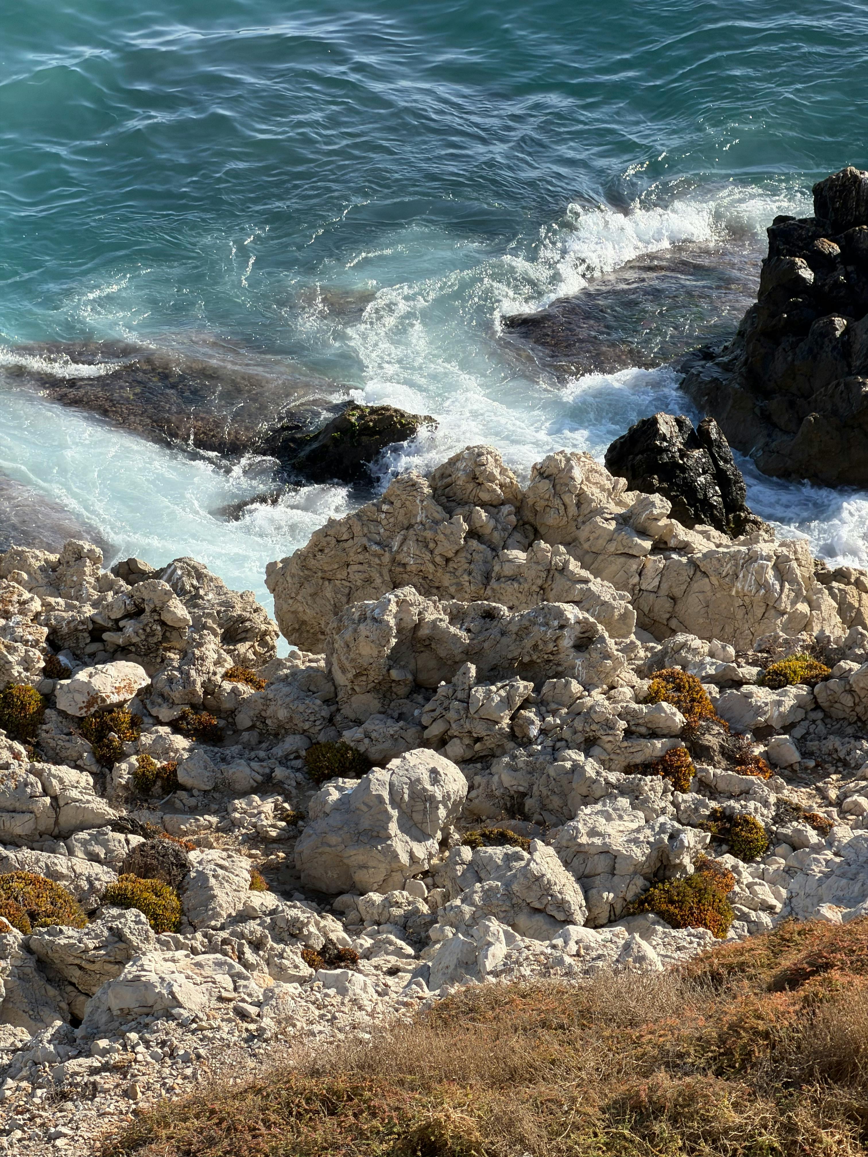 崎岖的海岸线，碧绿的海浪拍打着海岸，描绘出一幅自然美景