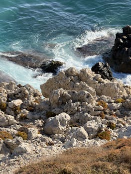 崎岖的海岸线，碧绿的海浪拍打着海岸，描绘出一幅自然美景