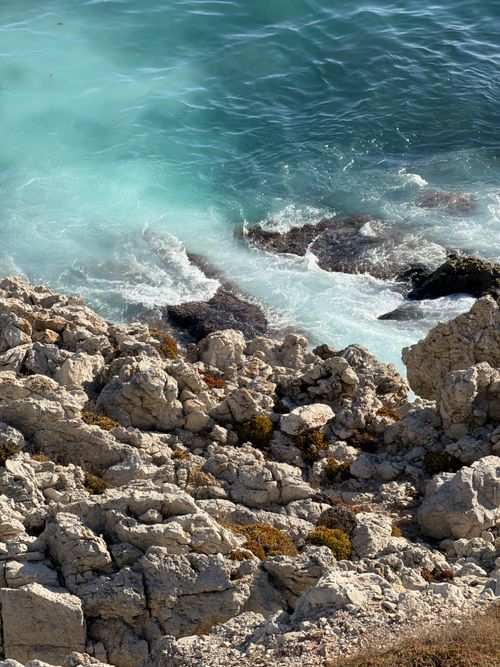 Free Stunning view of a rocky coastline with turquoise ocean waves crashing ashore. Stock Photo