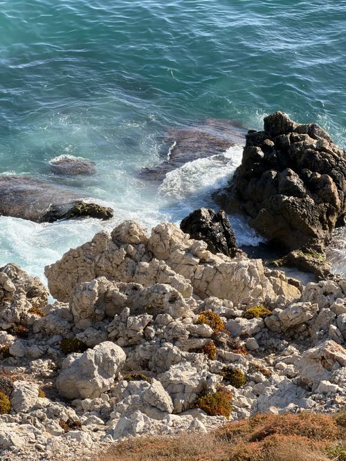 Free Serene view of a rocky shoreline and waves crashing at a beautiful beachfront. Stock Photo