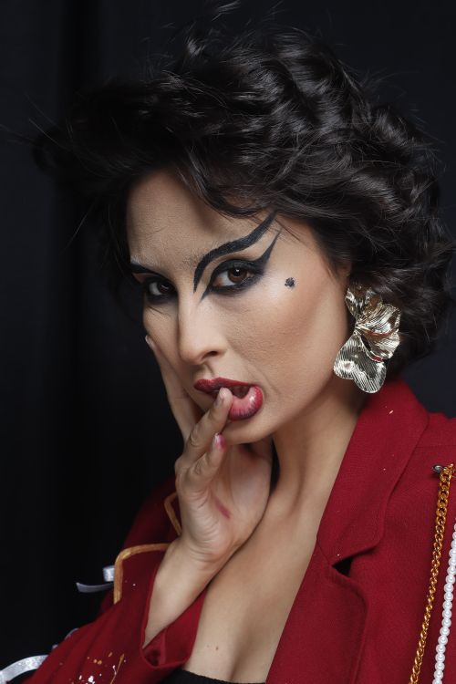 Free Stunning portrait of a woman with bold makeup and stylish accessories. Stock Photo