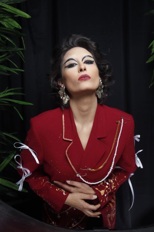 Free Stunning portrait of a stylish woman in a red jacket, set against a dark background. Stock Photo