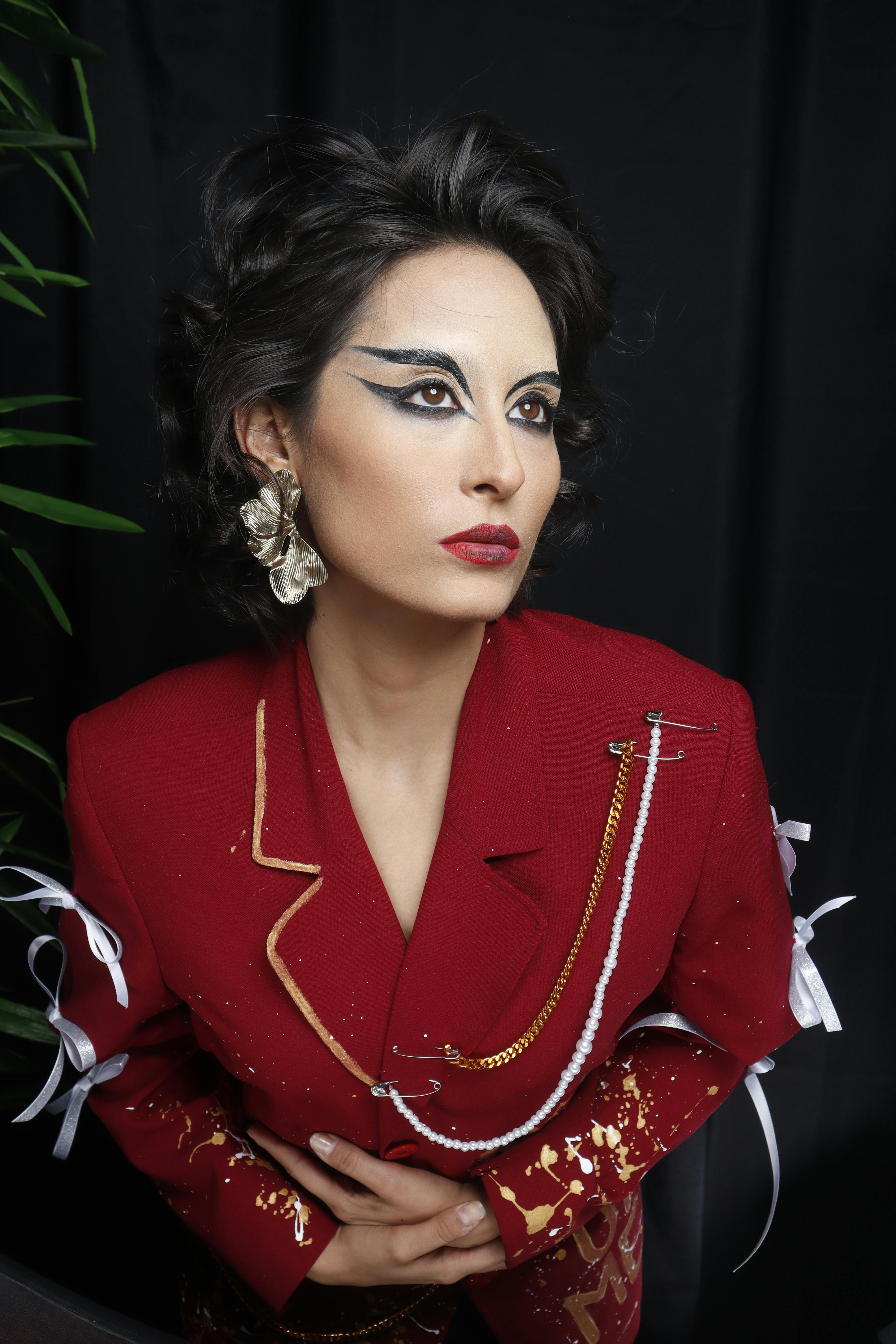 身着红色外套、妆容醒目、戴大耳环的优雅女子，肖像摄影