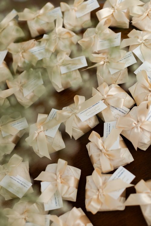 Free Chic wedding favors adorned with cream satin bows and tags, perfect for receptions. Stock Photo