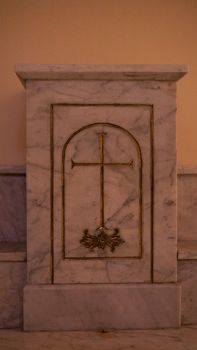 Elegant marble altar with ornate gold cross, indoors at a historic İstanbul church, showcasing religious artistry.