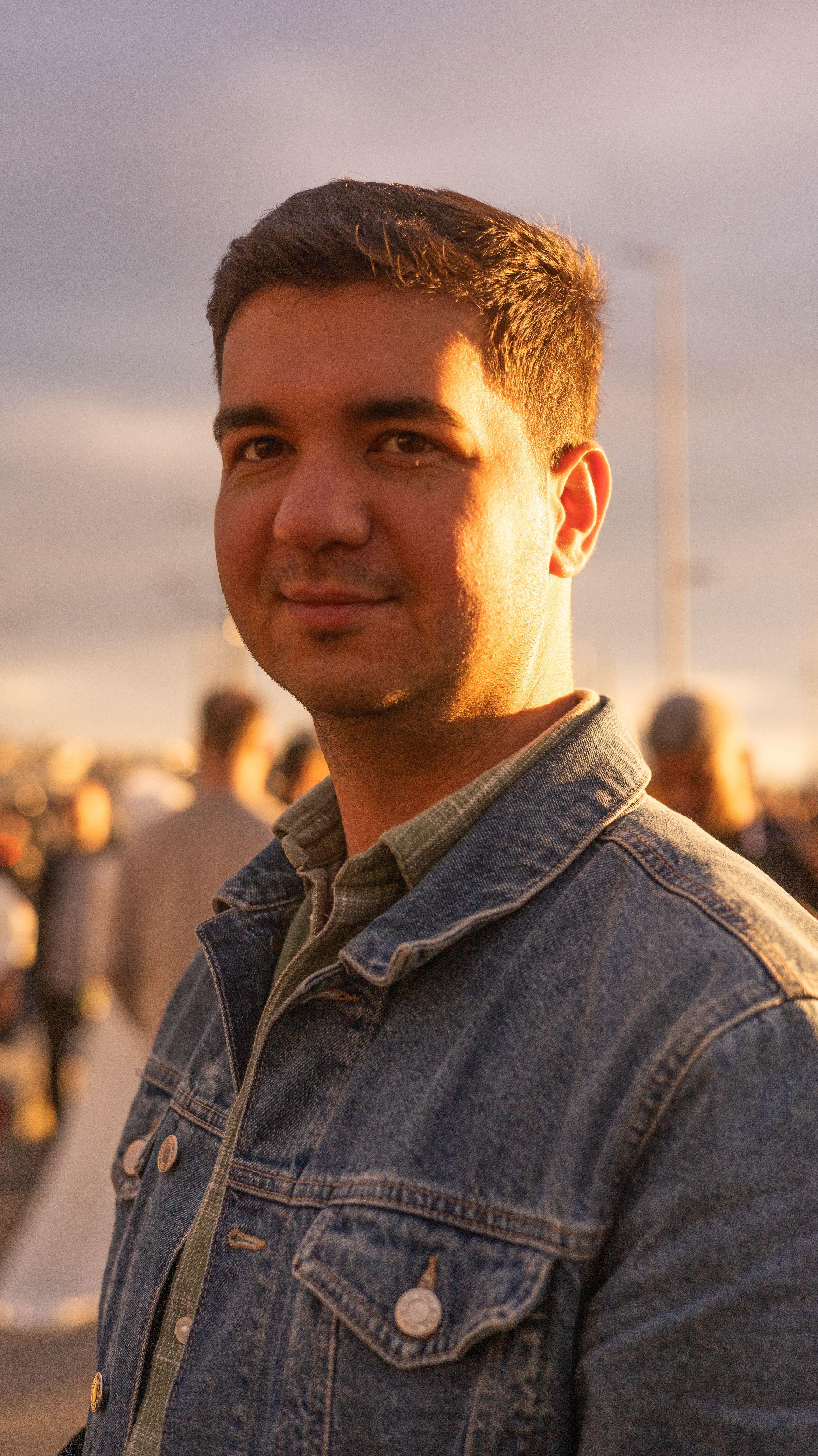 Portrait of a young man in a denim jacket during sunset in Istanbul, Türkiye.