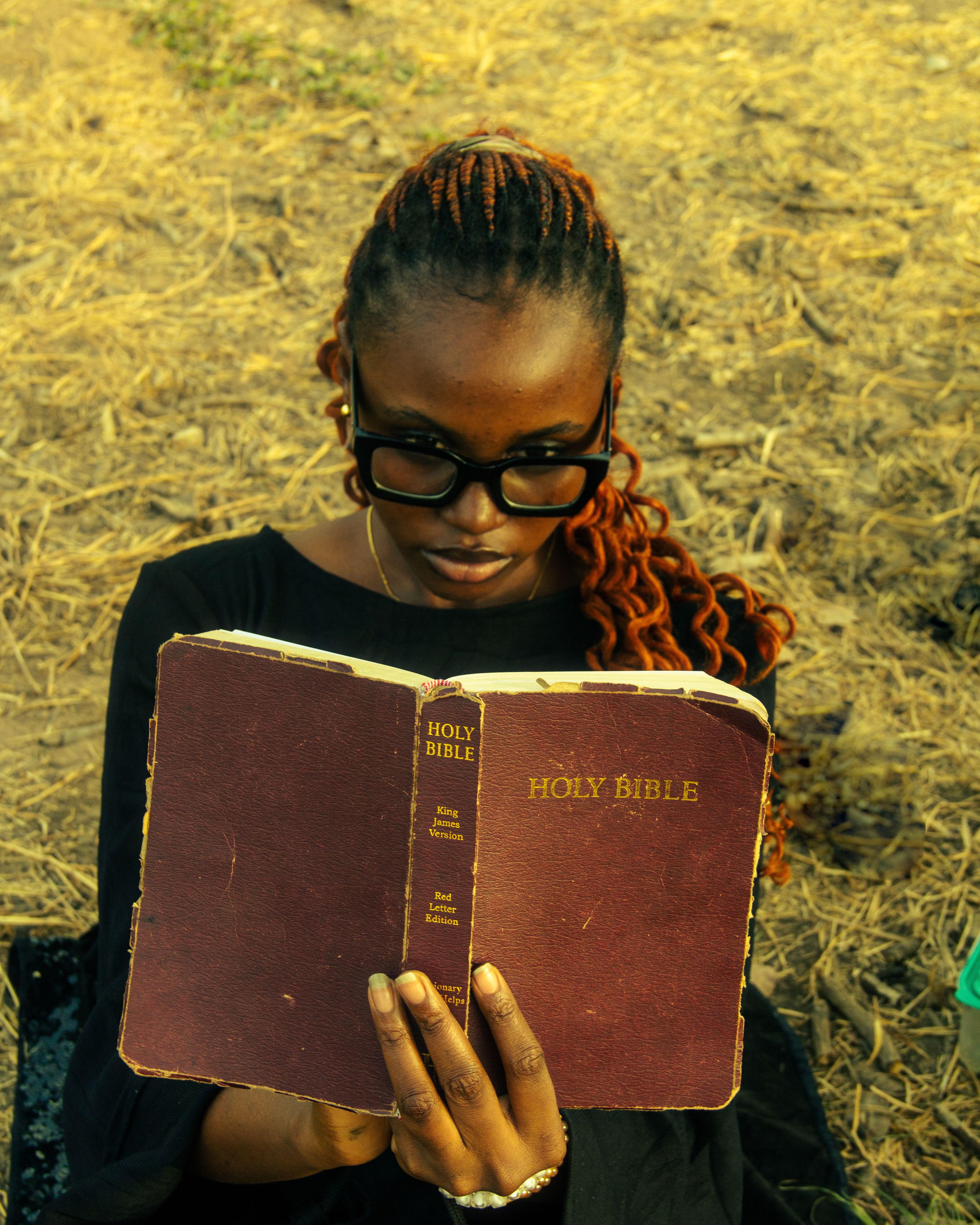 A young woman reading her Bible outdoors