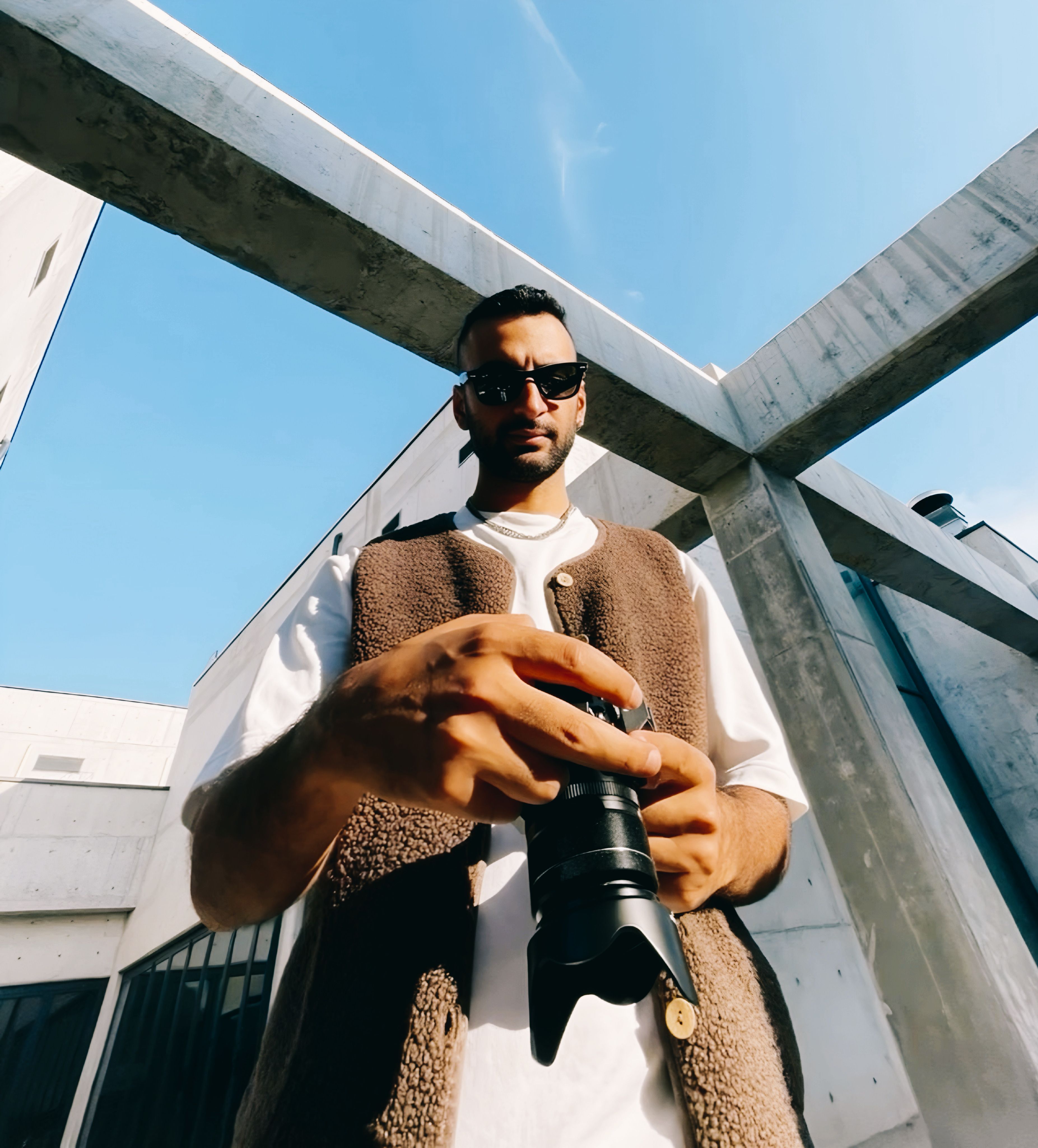 A photographer with a camera in Istanbul, surrounded by modern architectural structures.