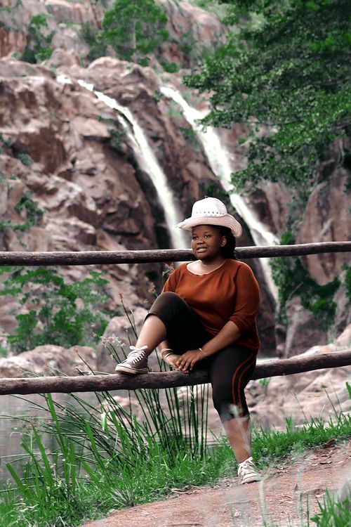 Free A woman enjoys the serene view of lush waterfalls in Buhleni, Eswatini. Stock Photo