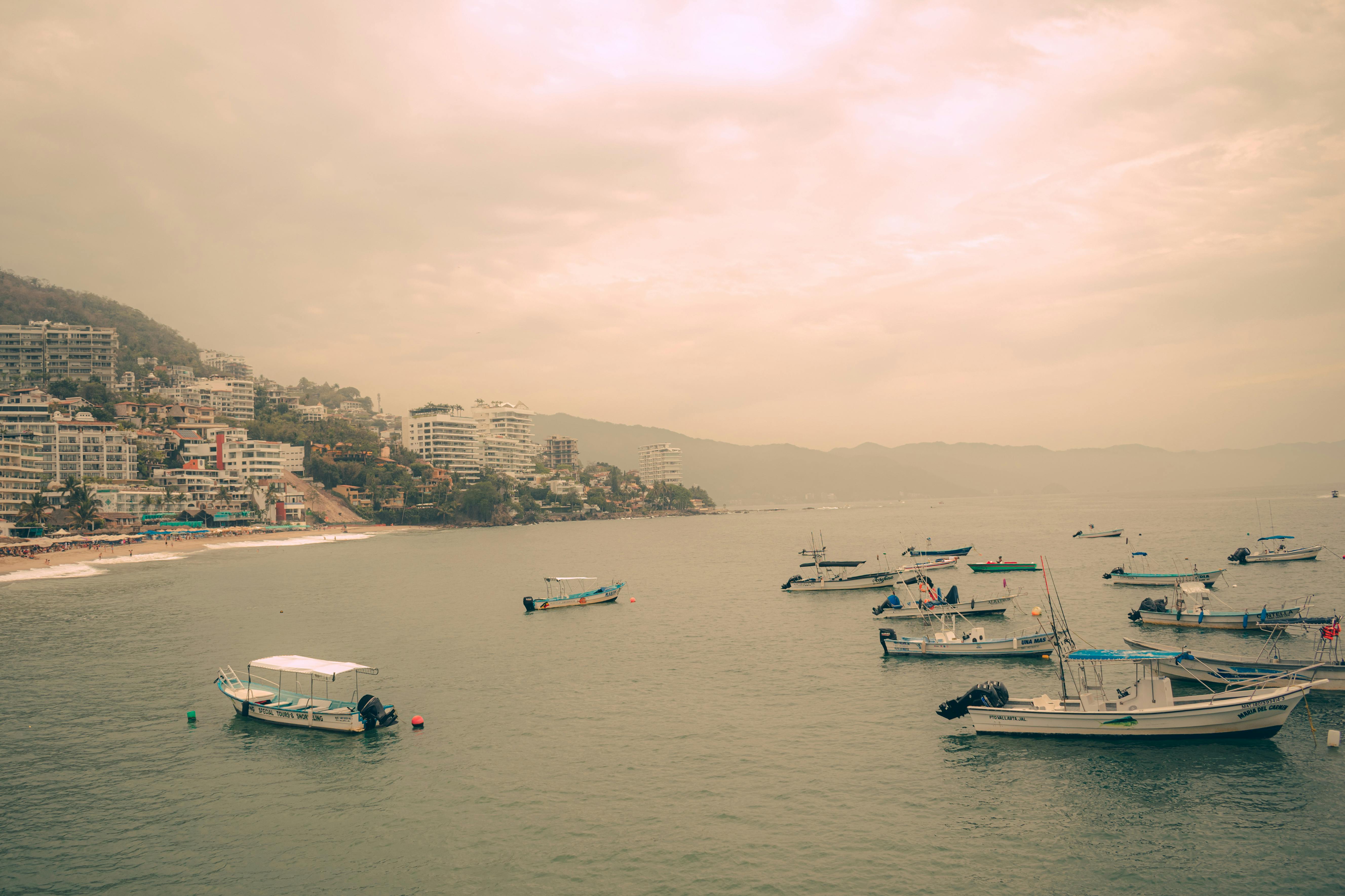 小船漂浮在岸边，沐浴在温暖的日落天空下