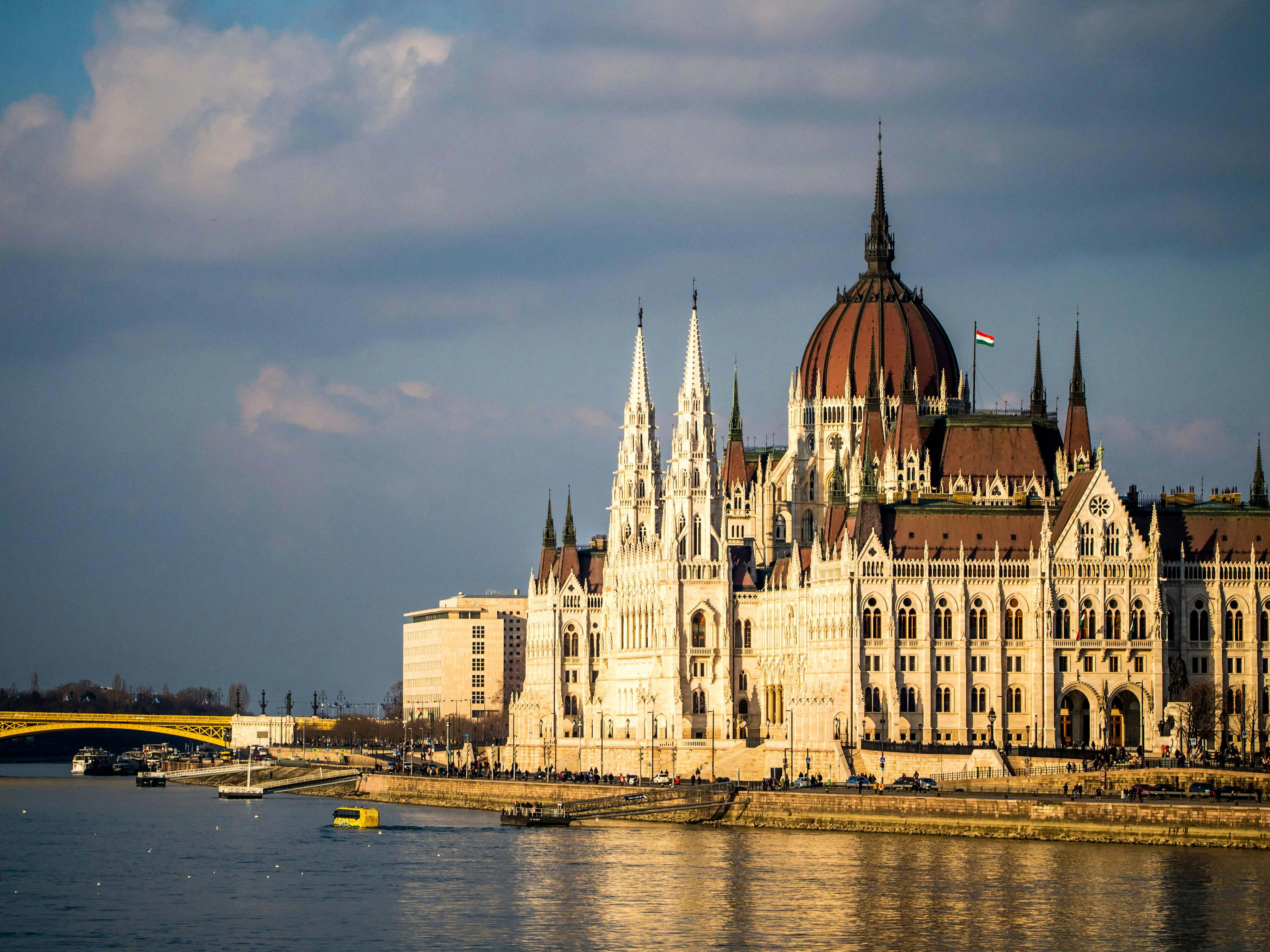 在多瑙河畔的日落天空下，匈牙利国会大厦展现出壮丽的景色