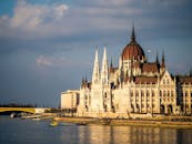 在多瑙河畔的日落天空下，匈牙利国会大厦展现出壮丽的景色