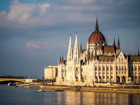 在多瑙河畔的日落天空下，匈牙利国会大厦展现出壮丽的景色