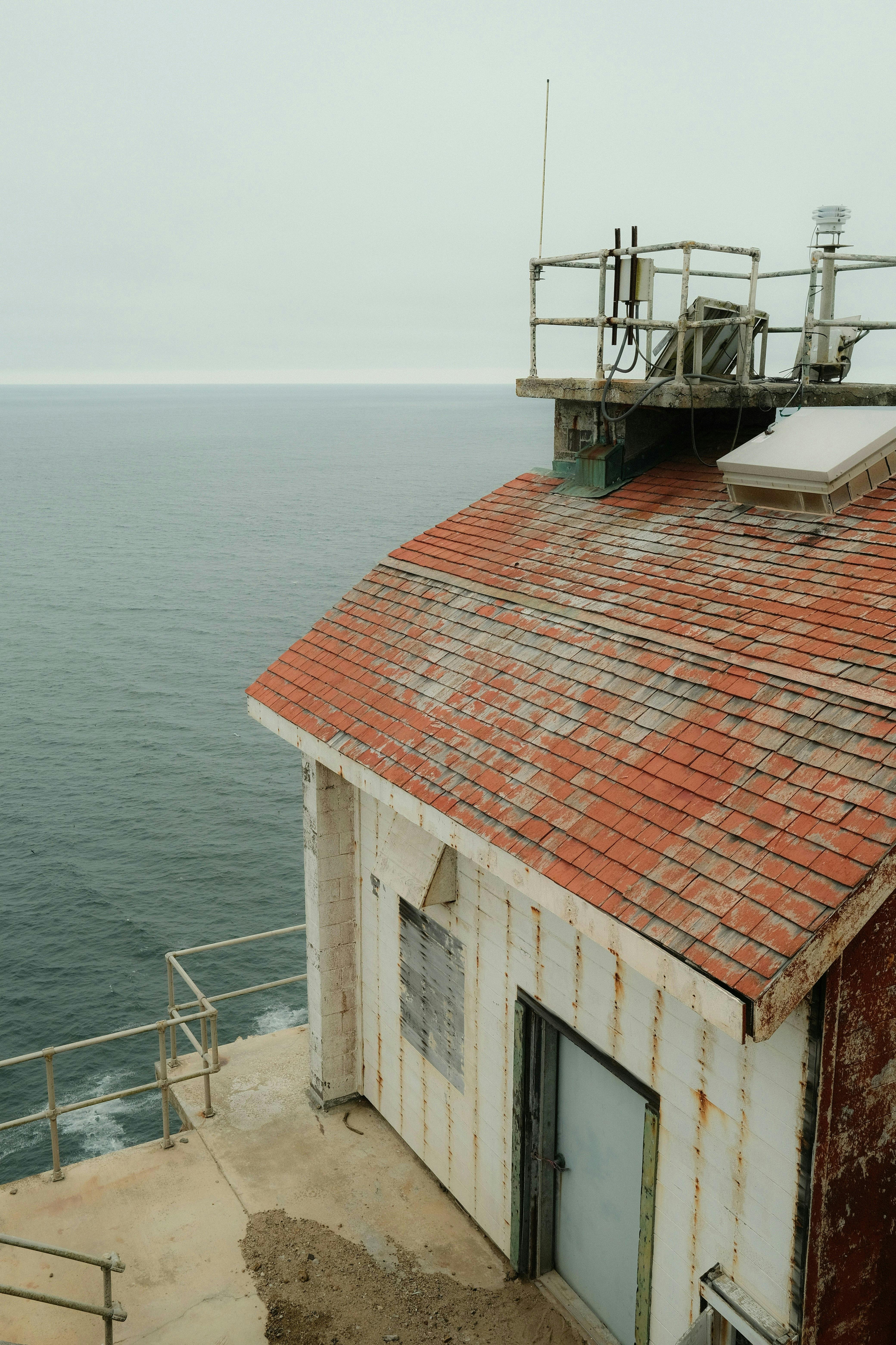 古老的灯塔，拥有红瓦屋顶和海洋背景，非常适合宁静的旅行视觉效果
